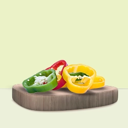 Sliced colourful bell peppers, including green, red, and yellow, are displayed on a wooden board, ideal for fresh and vibrant cooking recipes.