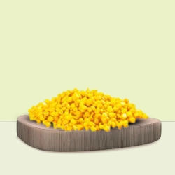 Sweet and juicy yellow corn kernels neatly piled on a wooden surface.