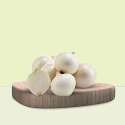 Fresh white garlic bulbs are arranged on a wooden board for culinary use.